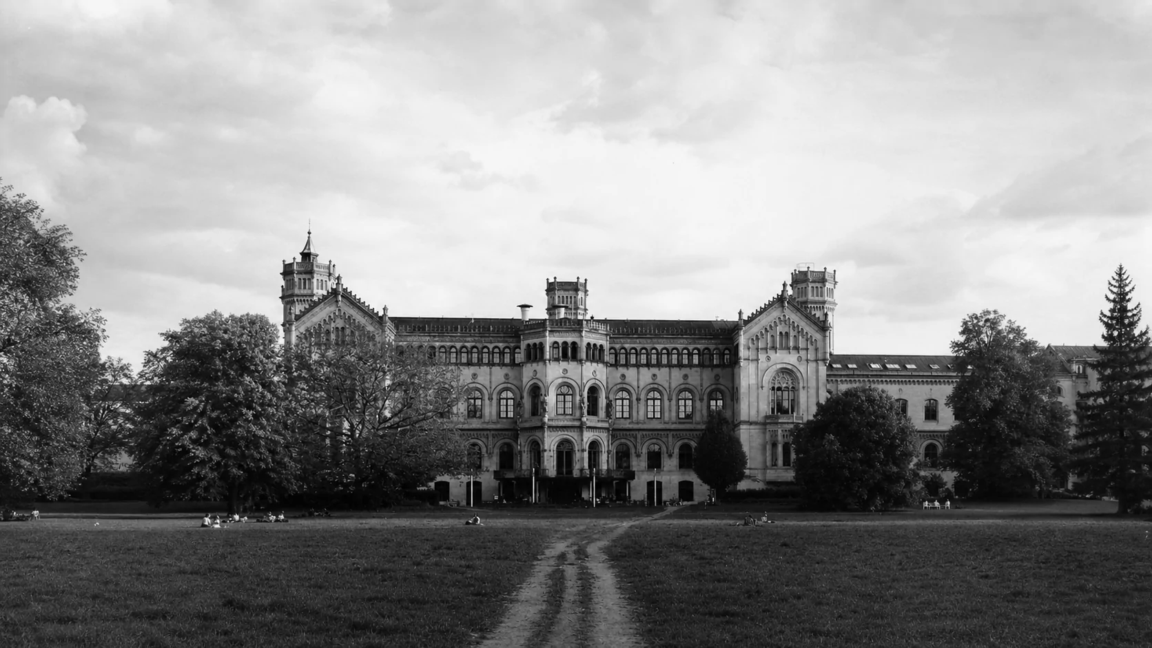 A historic European university building and its park